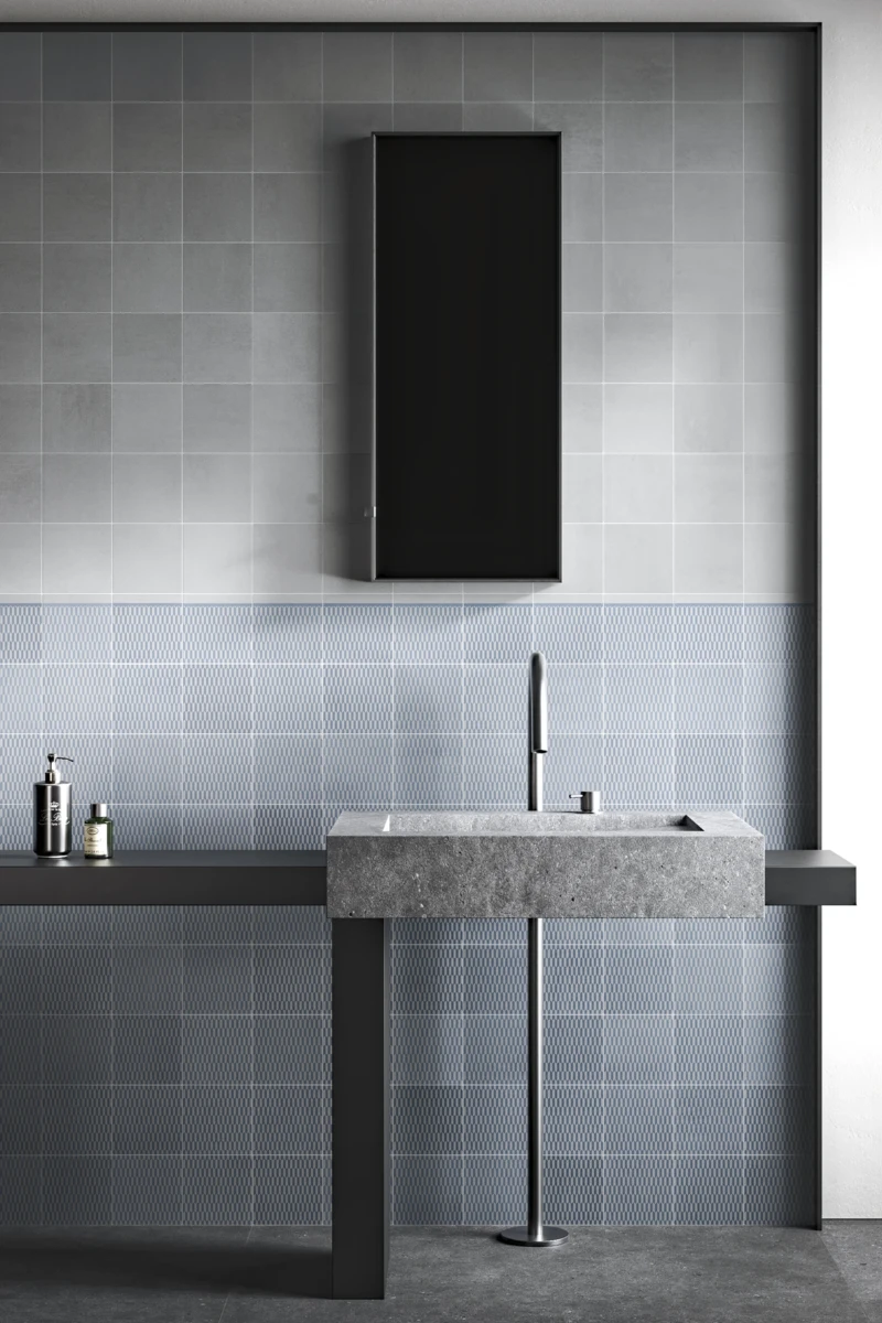 Badezimmer gestaltet mit grauen Fliesen und Design mit blauen Texturen